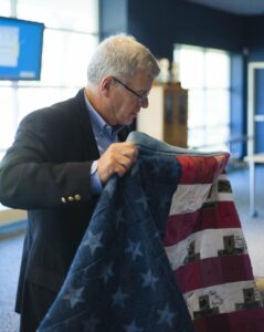 Gil Sanborn folds an American Flag quilt given to him by his “adopted platoon.” 