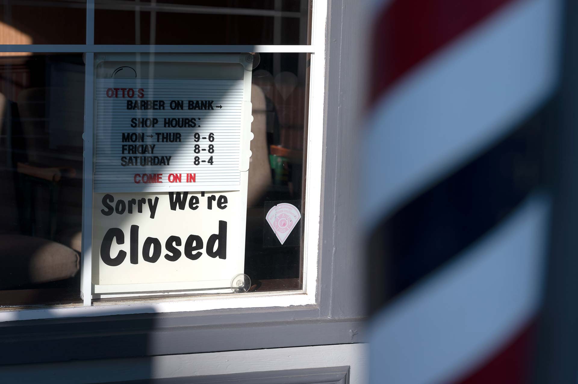 A closed sign on a barbershop in New London on April 15. As COVID-19 cases spread across Connecticut, the state shut down barbershops and salons in March. (Ryan Caron King/Connecticut Public)