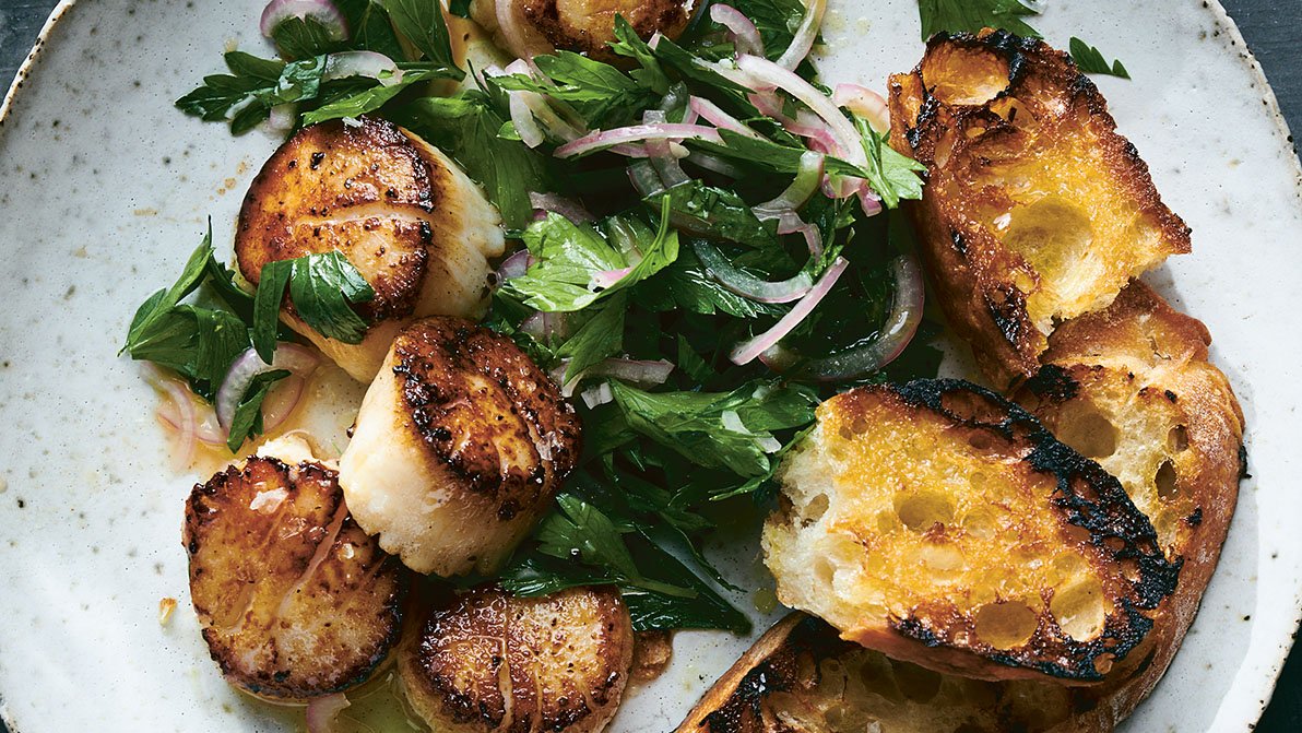 Seared Scallops with Parsley Salad recipe from The New York Times Cooking No-Recipe Recipe. Text copyright © 2021 by Sam Sifton and The New York Times Company. Photographs copyright © 2021 by David Malosh and Food Styling by Simon Andrews. Published by Ten Speed Press, an imprint of Random House, a division of Penguin Random House