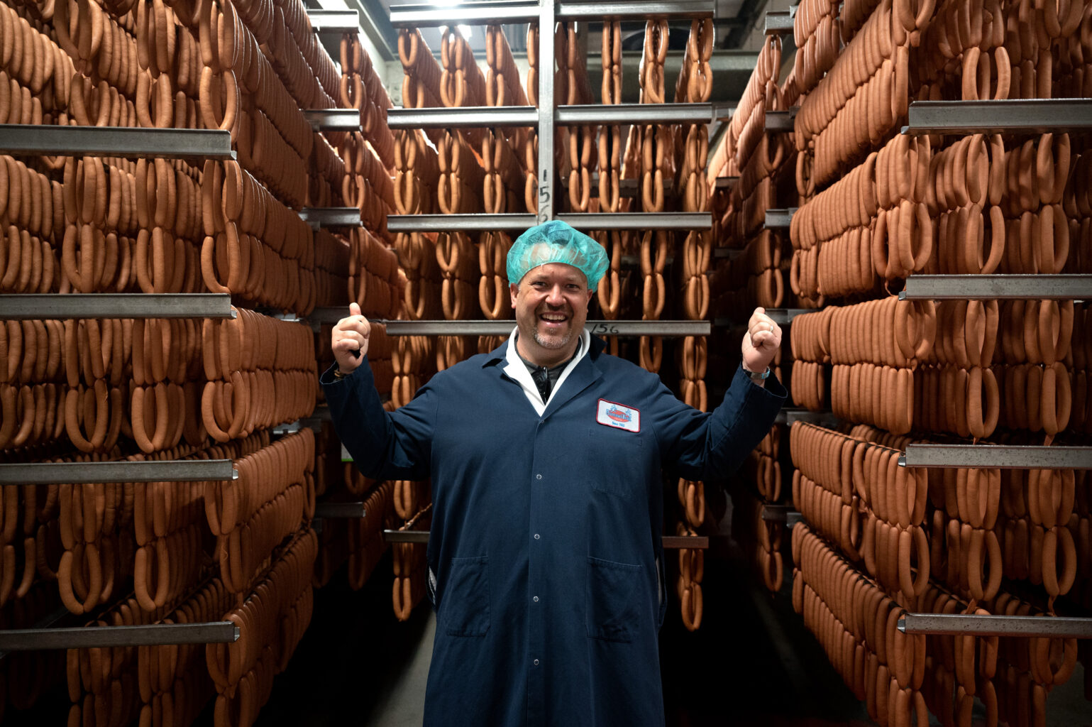 “Seasoned” host Chef Plum stands for a portrait in front of racks of cooling hot dogs at the Hummel Bros. factory in New Haven, Conn.  