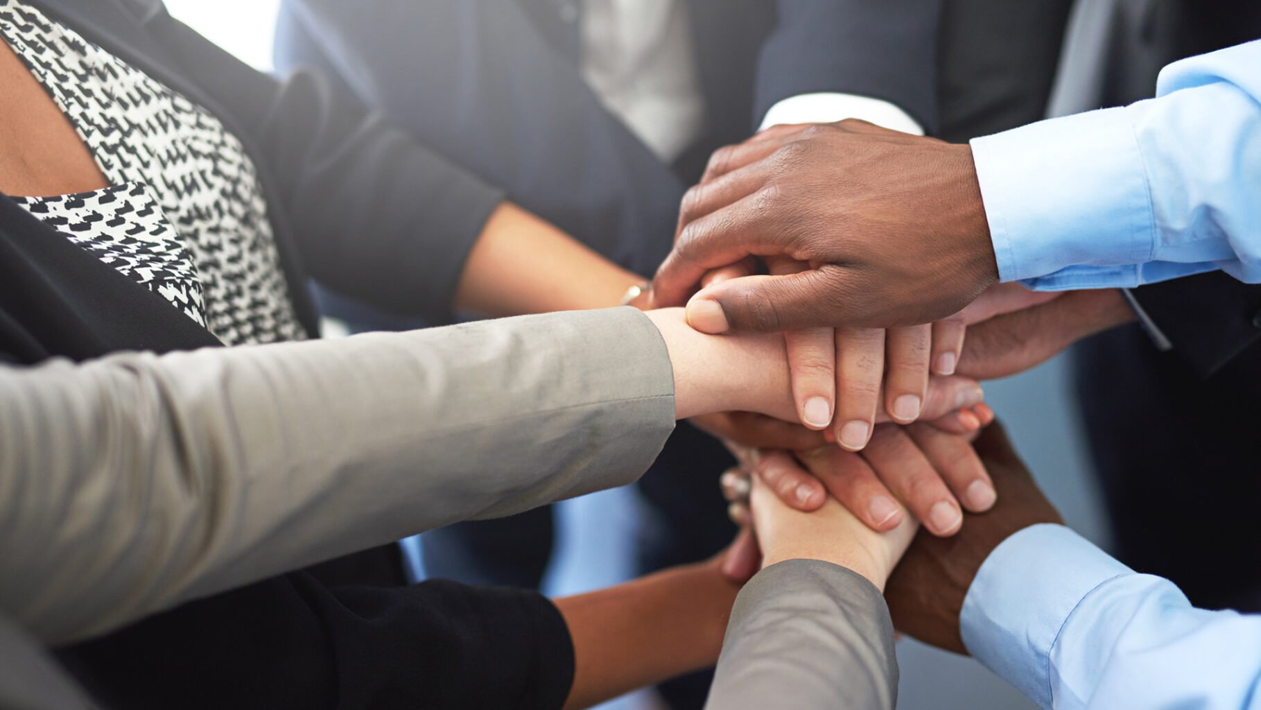 Cropped shot of a group of colleagues joining their hands in unity